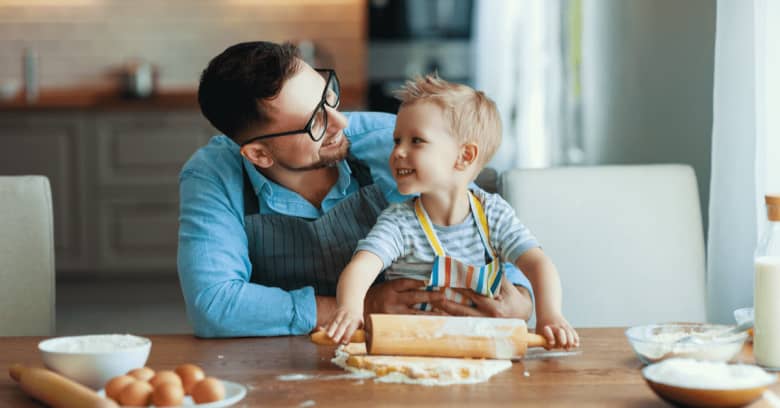 a man and his toddler son prepare a meal together at home