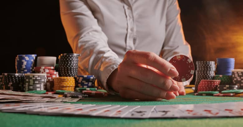 A dealer in a casino shuffles a deck of cards at a poker table