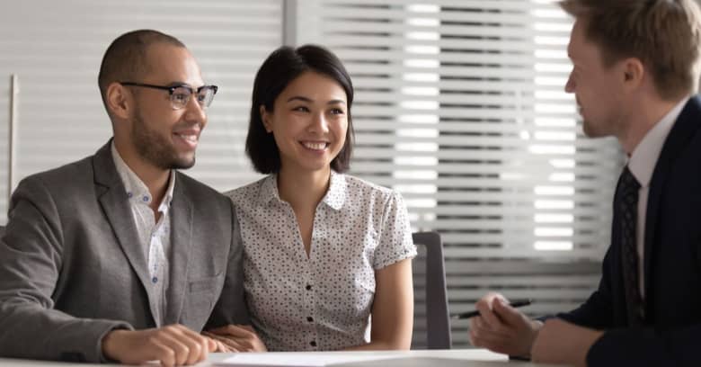 husband and wife discussing with an advisor and smiling
