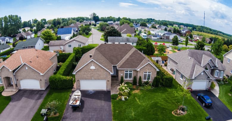a tidy suburban neighborhood is viewed from an aerial shot
