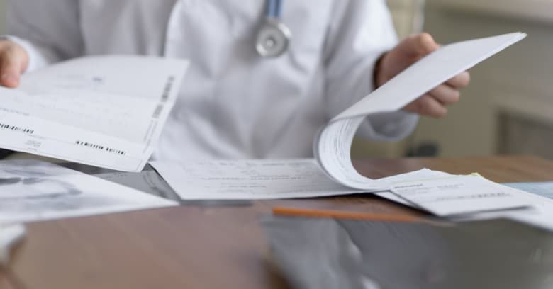 A doctor fills out medical paperwork in response to coronavirus