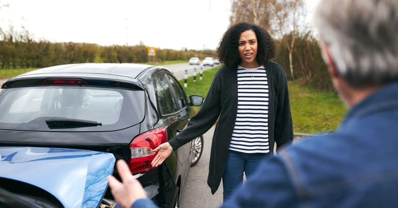 Two people on the side of the road after a car accident