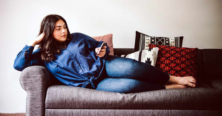 Woman checking phone on couch