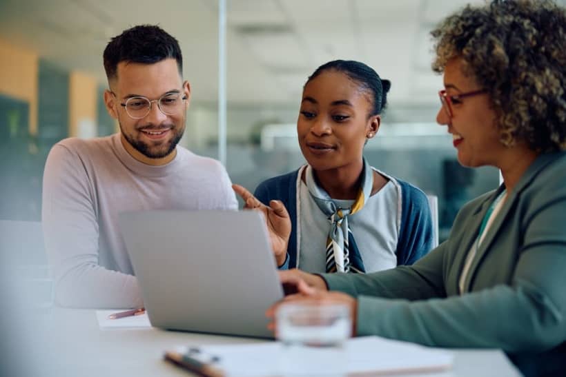 A young couple consults with their life insurance agent in the office.