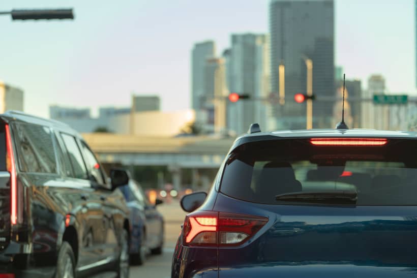 Cars stopped at a red light in city traffic.