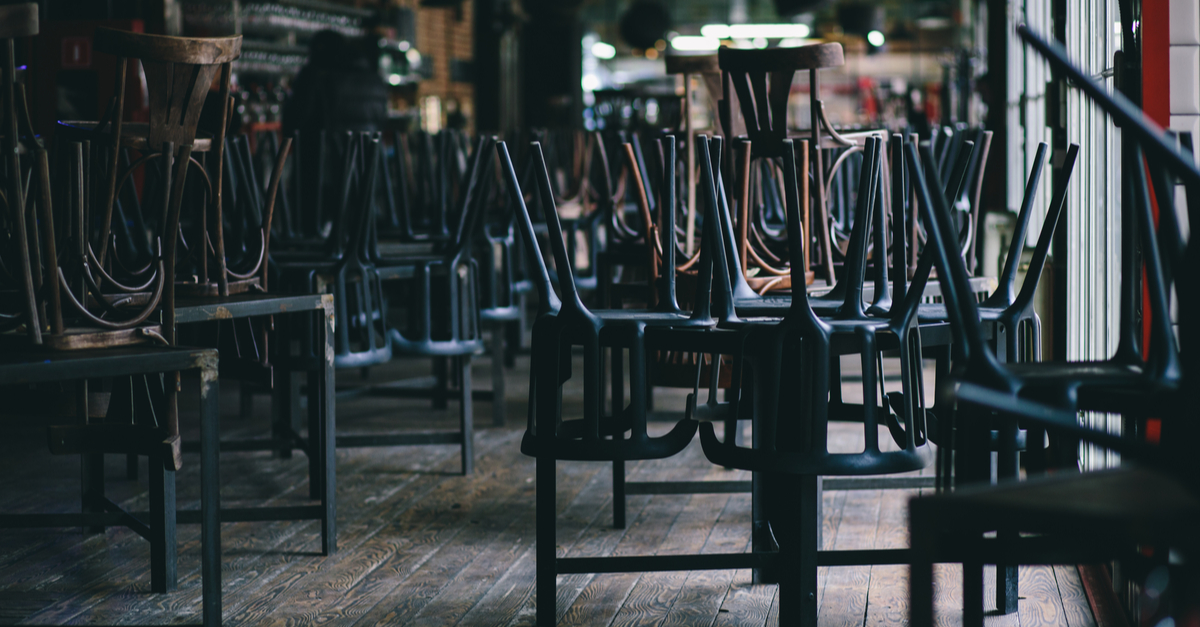 Chairs upside-down on tables in a closed restaurant.