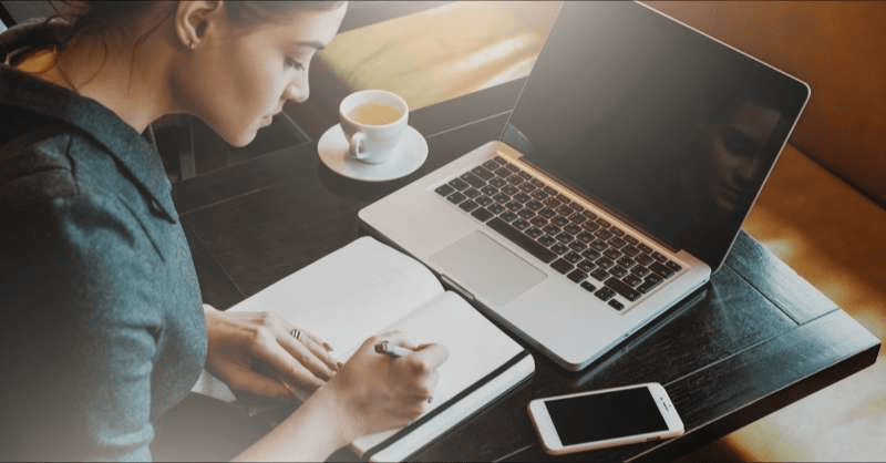  A freelance worker takes notes in front of her computer