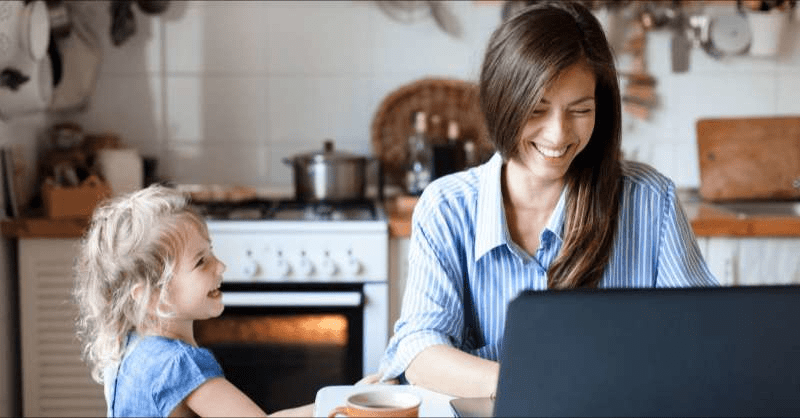 A freelance worker works from home while caring for her daughter.