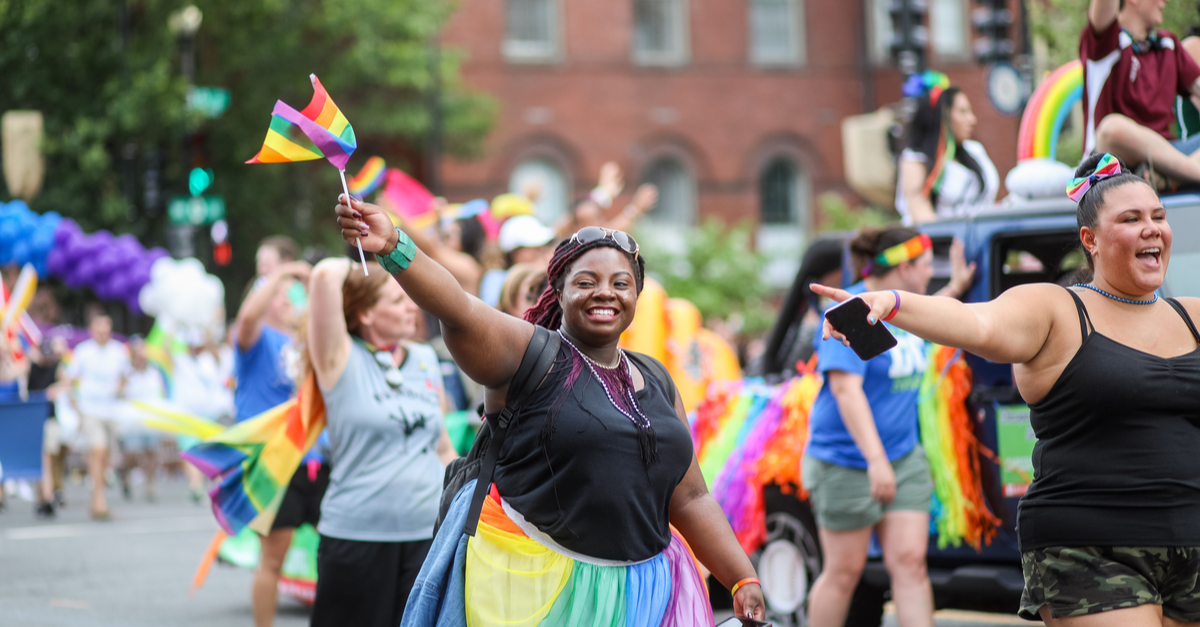 A woman enjoys walking in a parade during Pride Month