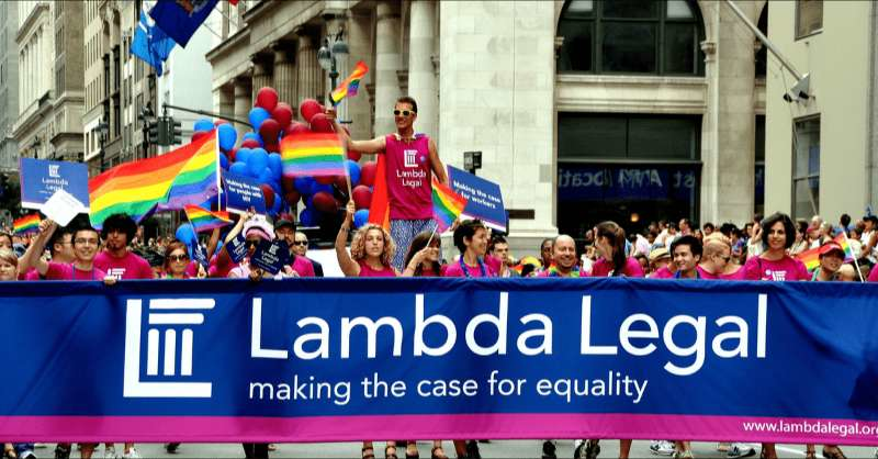 A group from Lamba Legal hold a sign during a pride parade in support of legal rights for LGBTQ+ people.