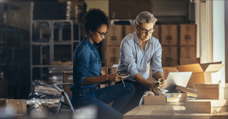 Two business owners are seen packing orders