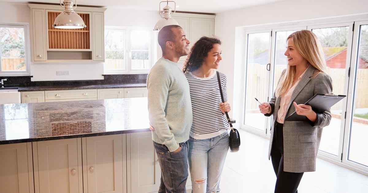 A realtor shows a new home to a couple.