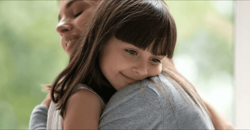 an LGBTQ+ mom gives her daughter a hug