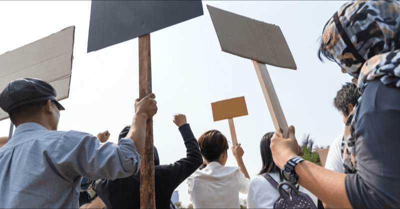 Protesters are seen holding signs