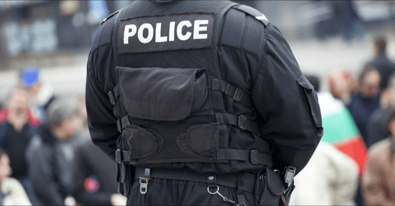 A police officer watches a crowd of protesters