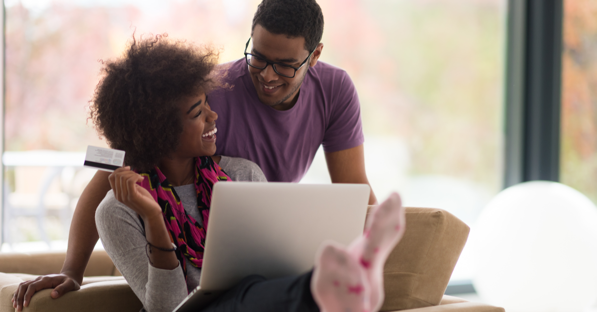 A couple uses their cash back credit card to shop online