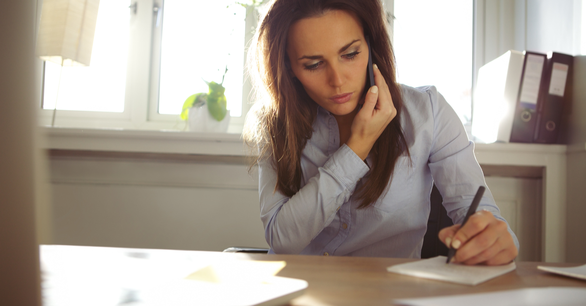 A woman researches savings and money market accounts on her computer while she takes notes