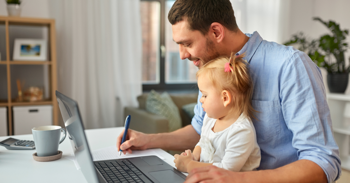 A man does calculations regarding his mortgage forbearance while he holds his toddler daughter in his lap