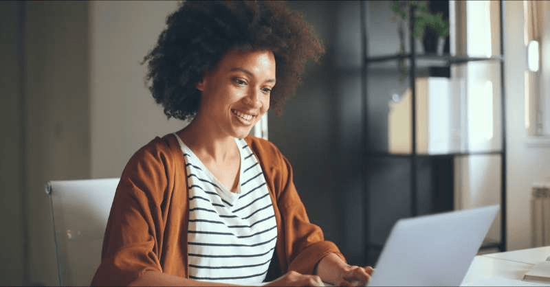 A content woman working on her taxes at her computer realizes she's getting a tax refund