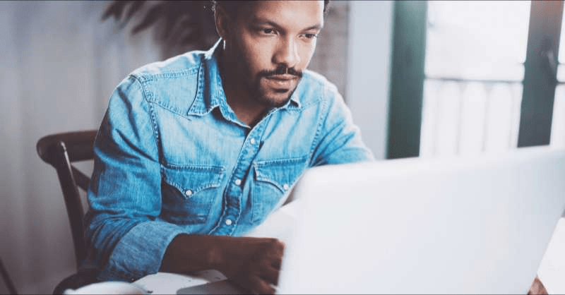 A concerned man realizes he owes taxes as he works on his tax returns on a computer