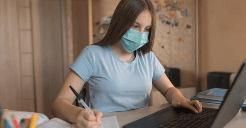 A female first-year college students works on homework in her dorm room