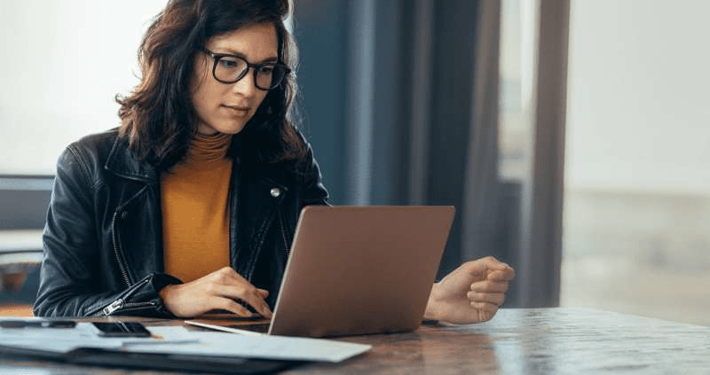 A woman uses her computer to research an organization she is considering donating to