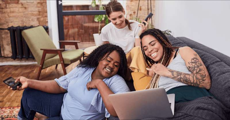 Three roommates enjoy a laugh in their home