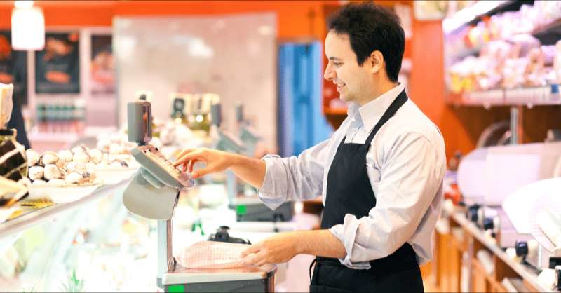 a man works behind the butcher counter at a grocery store