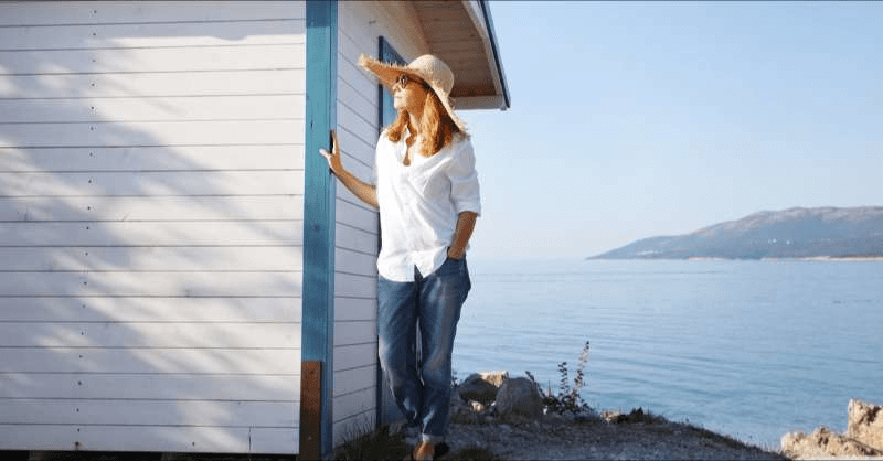 A woman is pictured by her coastal home