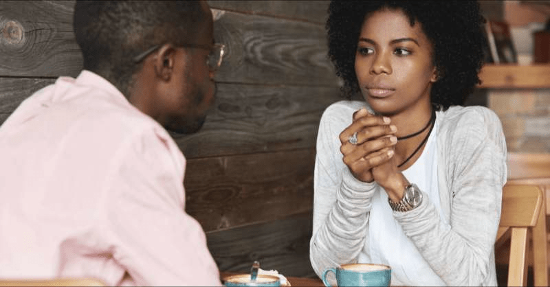 A man and woman are seen chatting in a coffee shop and discussing their financial goals