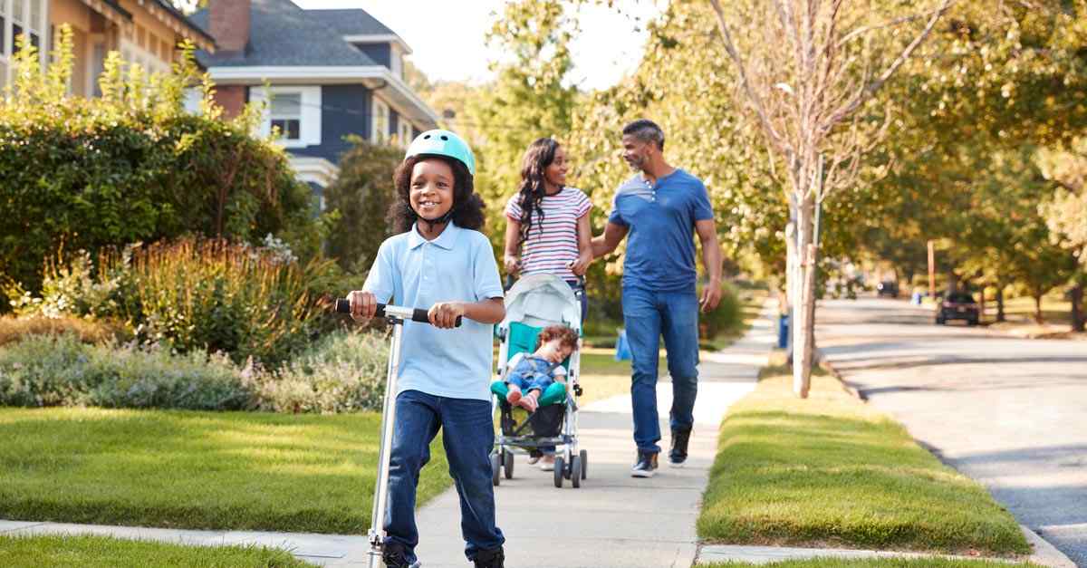 A couple and their two young children go for a walk in their new neighborhood after moving in.