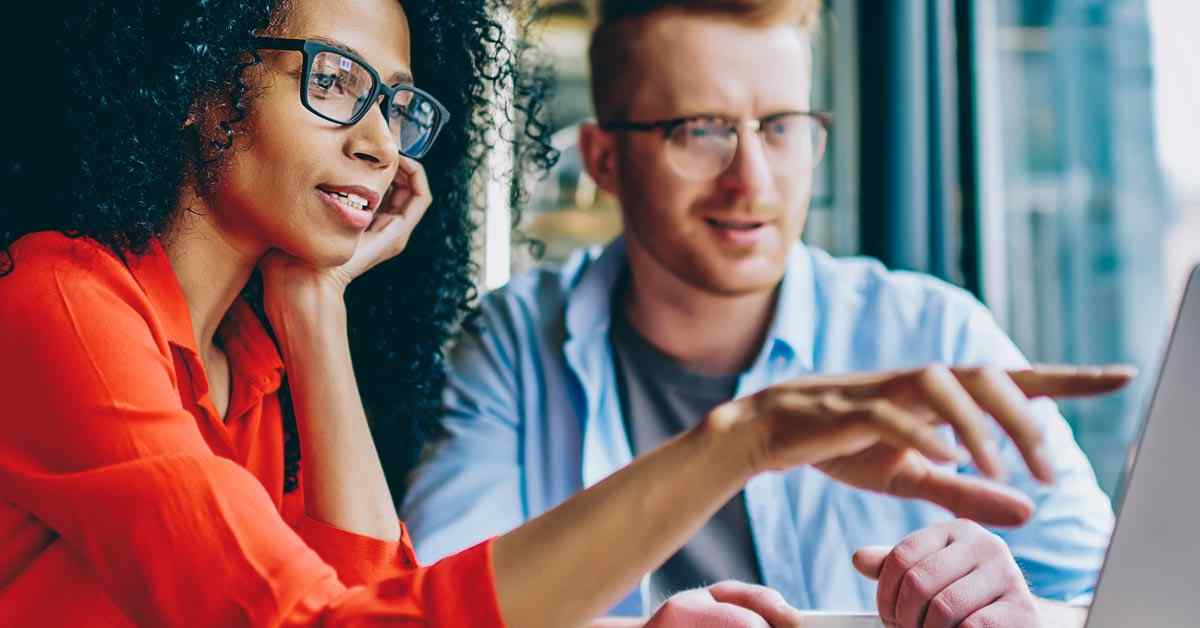 A man and woman review a mortgage application online to get approved for a home loan