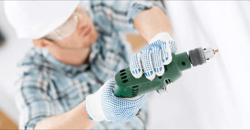 A subcontractor works on a home renovation while using a drill