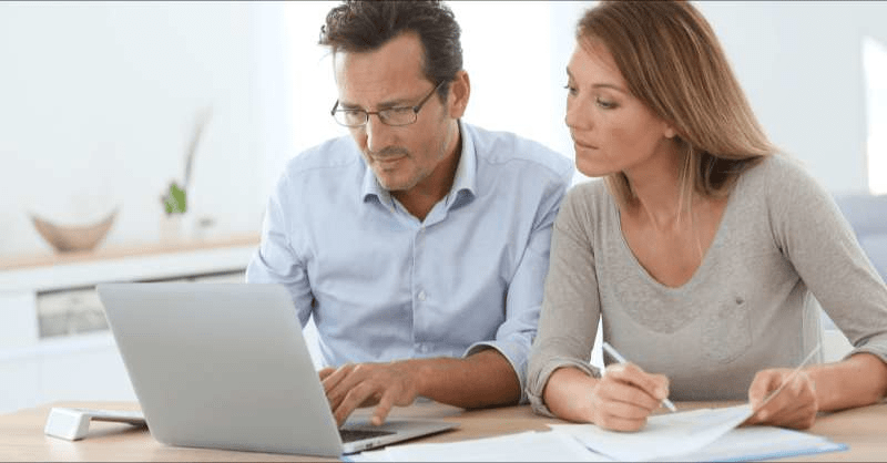 A couple looks at their computer as they check on their car insurance coverage