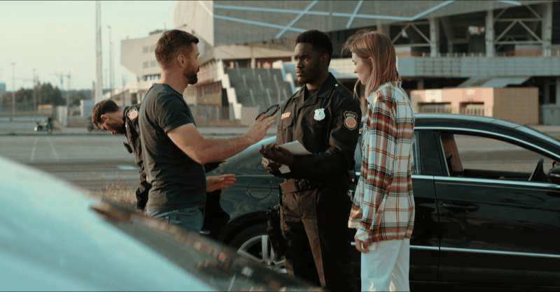 A police officer speaks with two drivers after a car accident