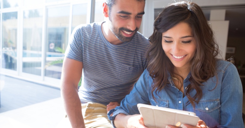 A couple looks at their tablet computer as they compare insurance rates online.