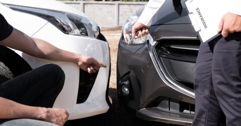 A car owner and an insurance adjuster discuss damage to a car.