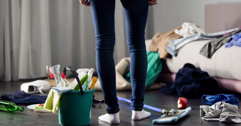 A housekeeper surveys a cluttered room and wonders how she will clean it