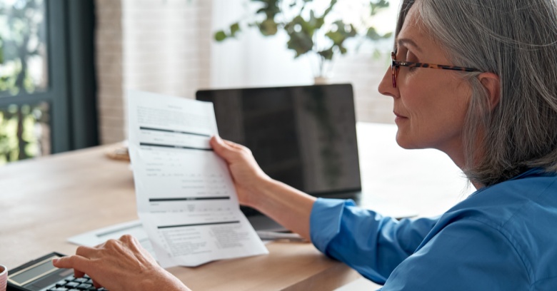 A woman looks at her computer as she determines how much of her tax refund she will add to her retirement account