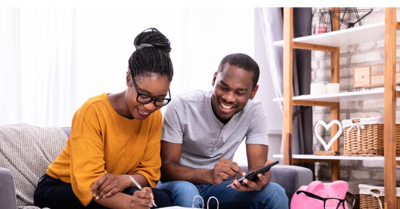 A couple looks at their computer while calculating how much of their tax return they will be able to contribute to their emergency savings