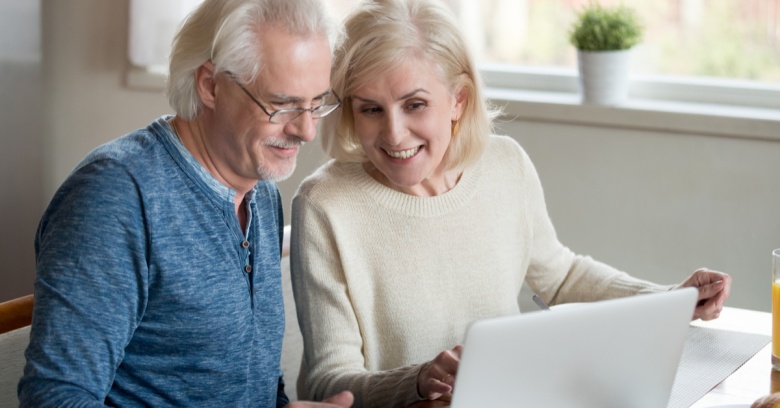 An older couple looks at life insurance policies online to determine which one they should purchase with their tax refund