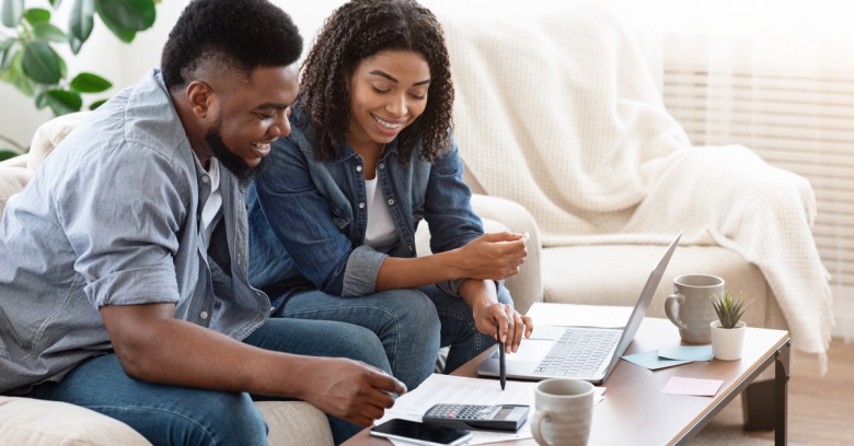 A young couple who are recent college graduates are working on creating a budget together.