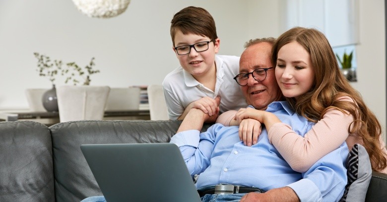 Family members look at the screen of a computer