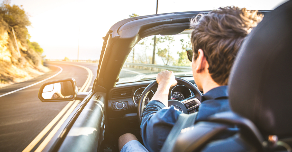 A man drives a sports car.