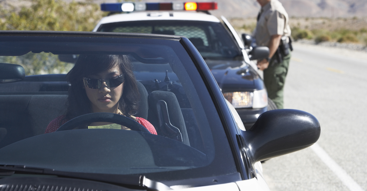 A woman gets pulled over by a police officer.