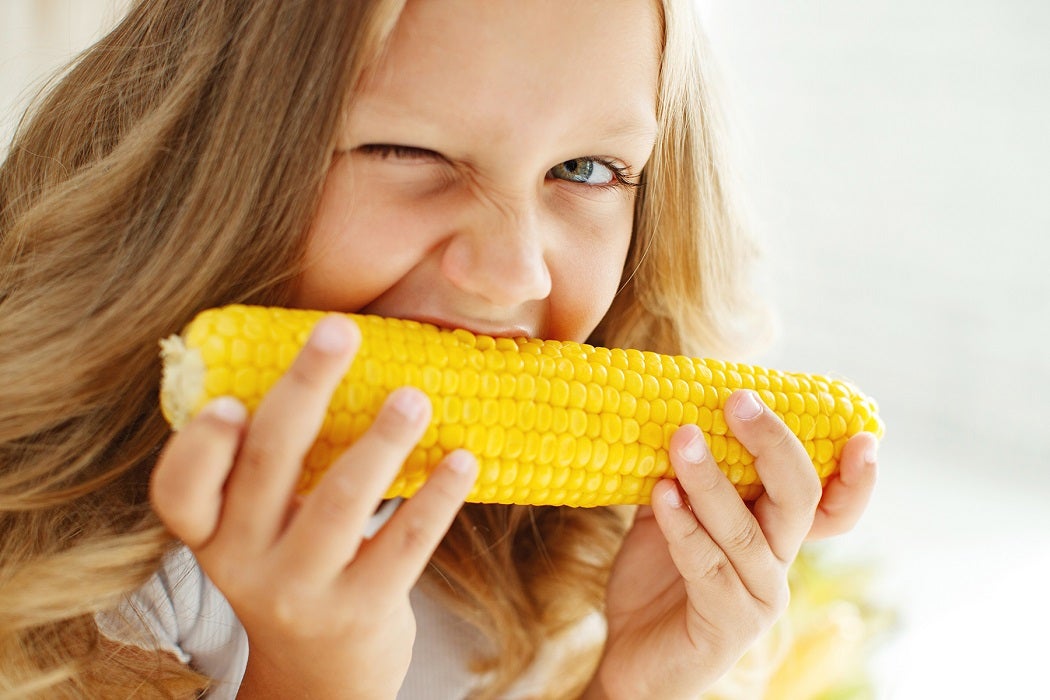Little girl eating sweet corn