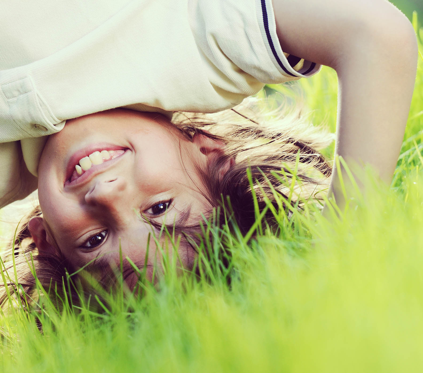 Kid doing handstand in grass