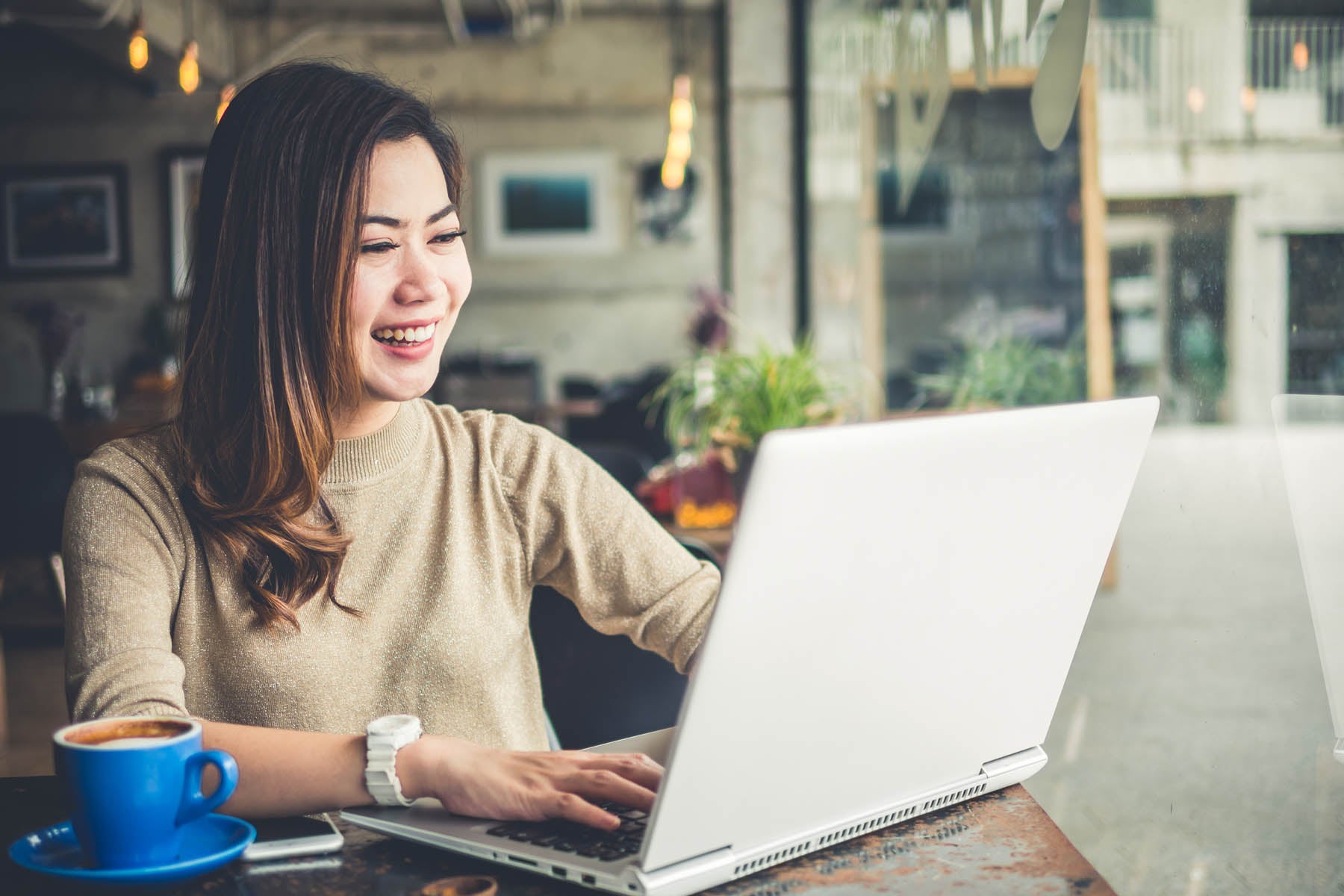 Woman working on computer in coffee shop