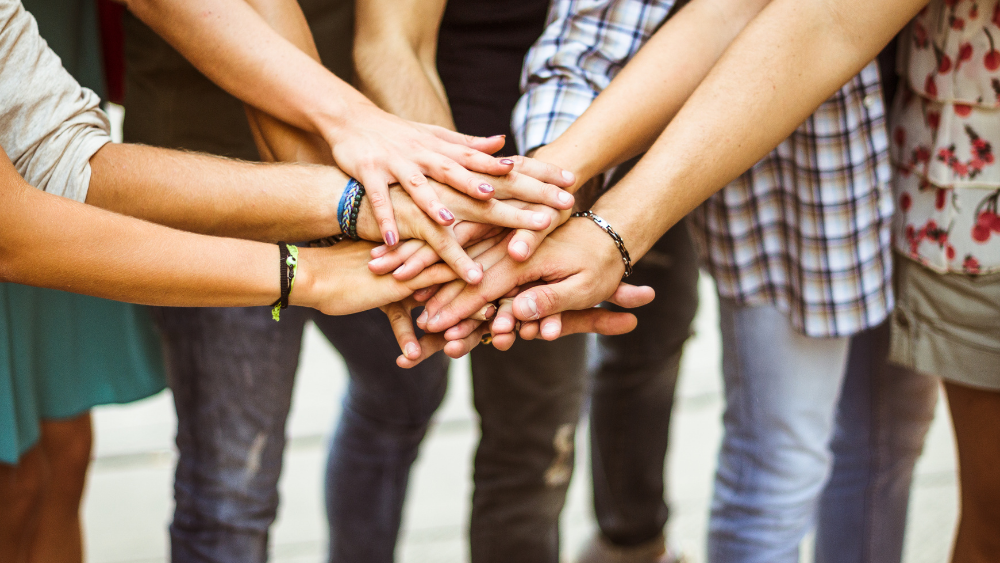 Team stacking hands and coming together