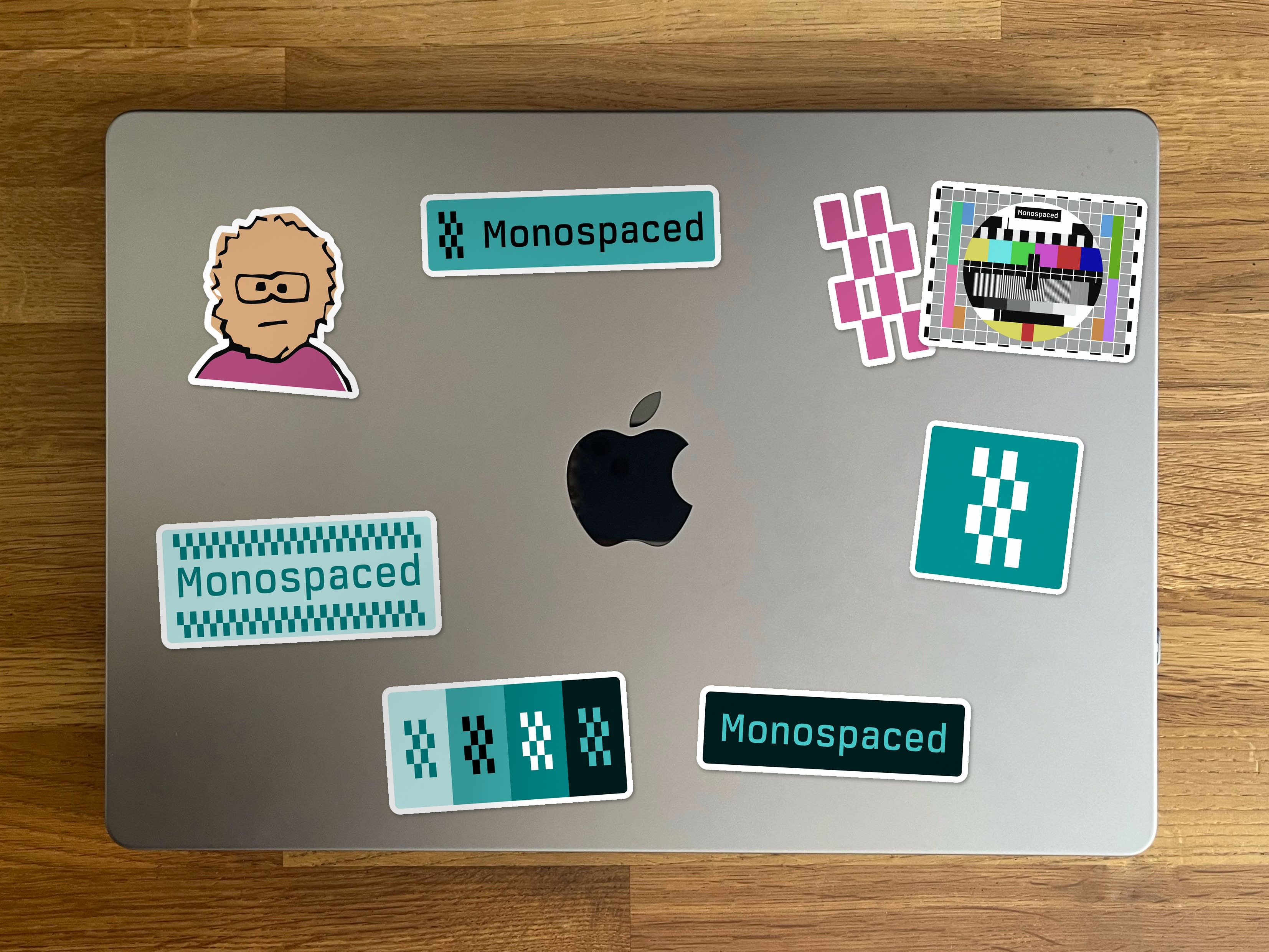 Photograph of a laptop sticker-bombed with Monospaced brand stickers